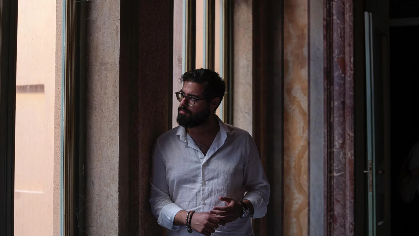 Giovanni Berardi accanto alle finestre di un palazzo storico